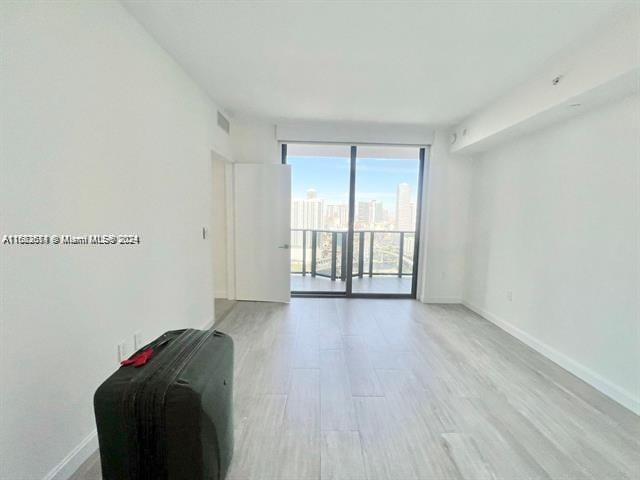 unfurnished room with light wood-type flooring