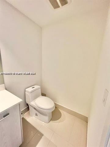 bathroom with vanity, tile patterned flooring, and toilet