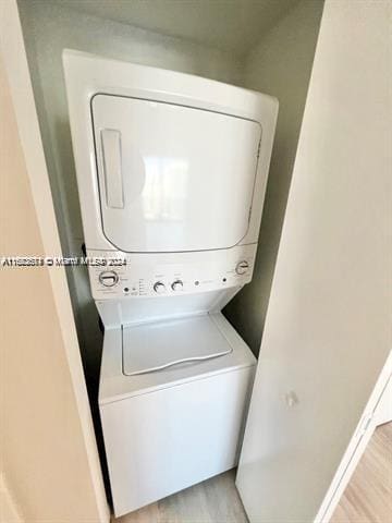 45 SW 9th St Unit 3009, Miami, FL 33130 - clothes washing area with stacked washing machine and dryer and light wood-type flooring