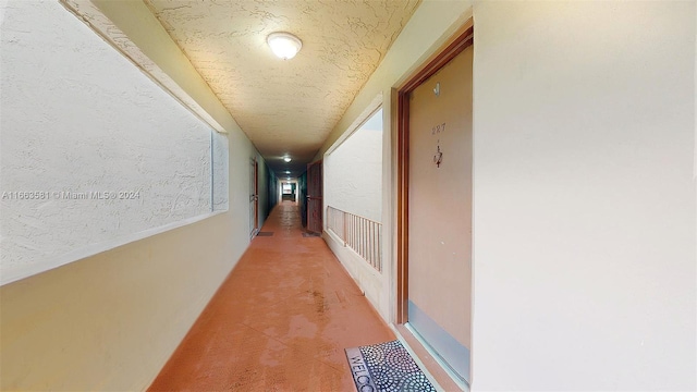 corridor featuring carpet floors and a textured ceiling