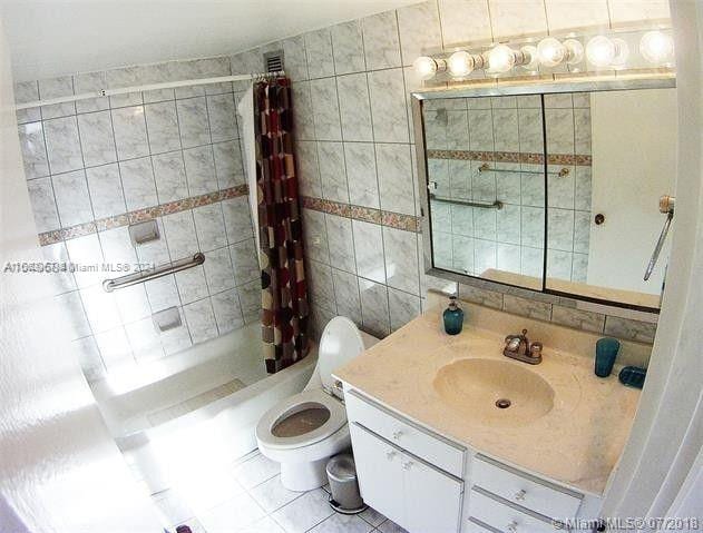 bathroom featuring a shower with shower curtain, tile walls, vanity, and toilet