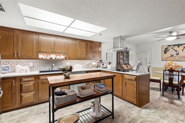 kitchen featuring sink, a skylight, island exhaust hood, black electric stovetop, and backsplash