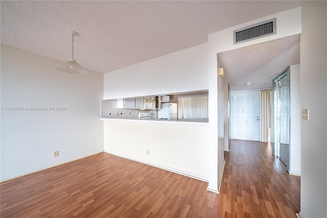 unfurnished living room featuring a textured ceiling and hardwood / wood-style flooring