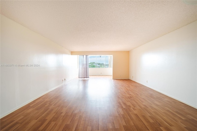 unfurnished living room with a textured ceiling and hardwood / wood-style flooring