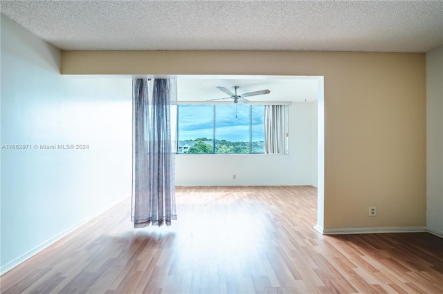 spare room featuring a textured ceiling, light hardwood / wood-style floors, and ceiling fan