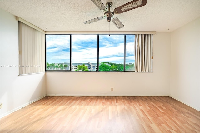 unfurnished room featuring light hardwood / wood-style floors, ceiling fan, and a textured ceiling