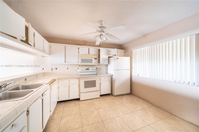 kitchen with ceiling fan, white cabinets, sink, white appliances, and backsplash