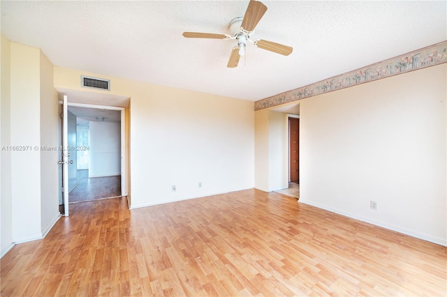 unfurnished room with a textured ceiling, light hardwood / wood-style floors, and ceiling fan