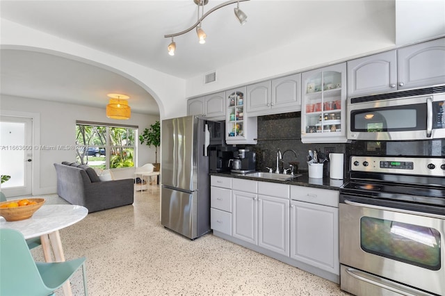 kitchen featuring appliances with stainless steel finishes, sink, gray cabinets, and tasteful backsplash