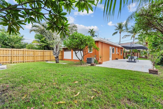 view of yard with central AC unit and a patio area