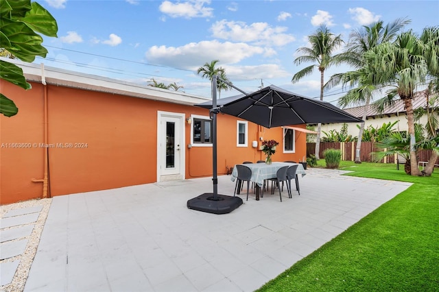 back of property with a lawn and a patio area