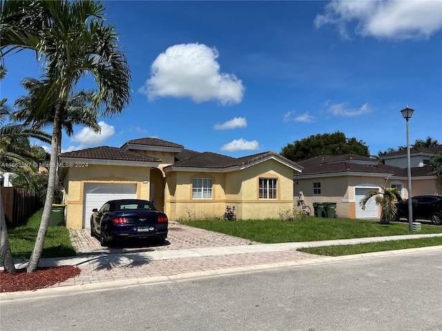 mediterranean / spanish-style house with a front yard and a garage