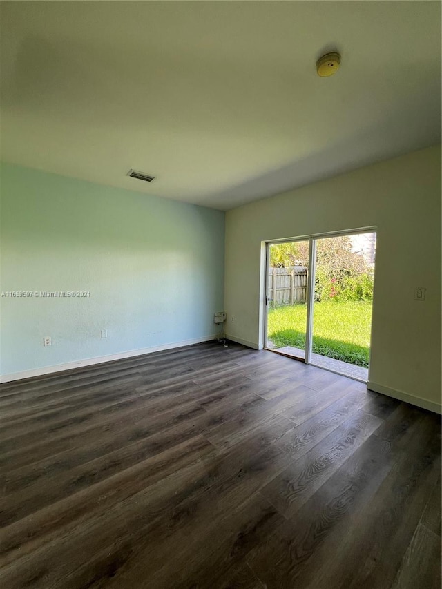 unfurnished room with dark wood-type flooring