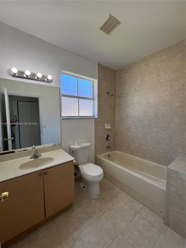 full bathroom featuring tile patterned floors, vanity, toilet, and tiled shower / bath combo