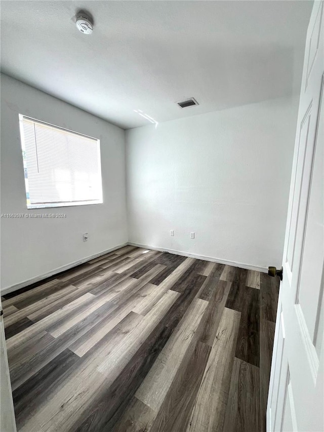 unfurnished room featuring dark hardwood / wood-style flooring