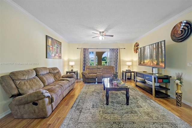 living room featuring ceiling fan, a textured ceiling, crown molding, and wood-type flooring