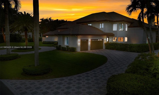 view of front of home featuring a garage and a yard