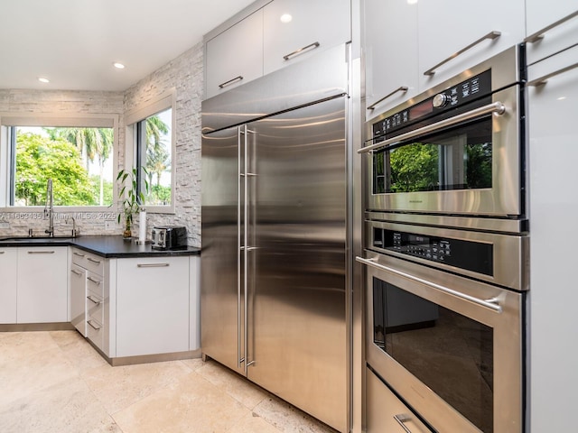 kitchen featuring sink, white cabinetry, appliances with stainless steel finishes, and tasteful backsplash