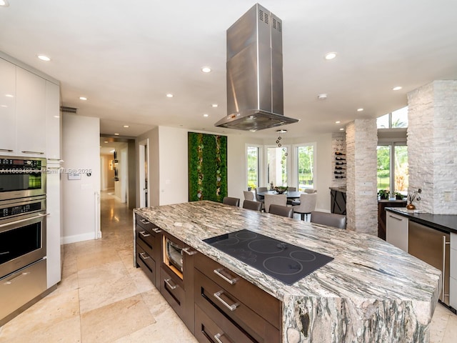 kitchen with a spacious island, white cabinets, island exhaust hood, light stone counters, and black electric cooktop