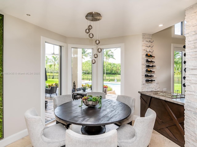 dining space featuring light tile patterned flooring and a healthy amount of sunlight