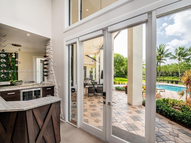 doorway to outside with light hardwood / wood-style flooring and wine cooler