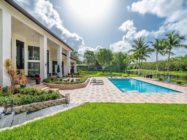 view of pool with a lawn and a patio