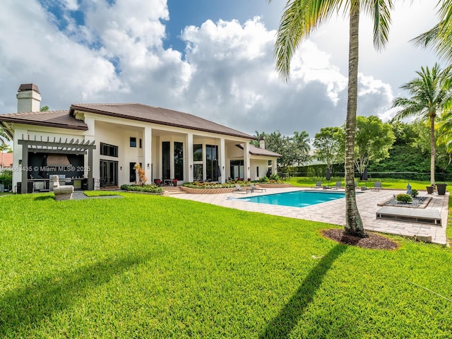 rear view of house with a fenced in pool, a patio area, and a yard