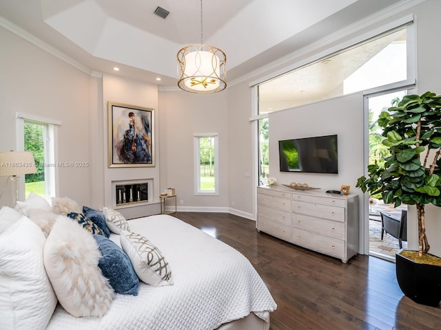 bedroom featuring access to outside, dark wood-type flooring, ornamental molding, and a raised ceiling