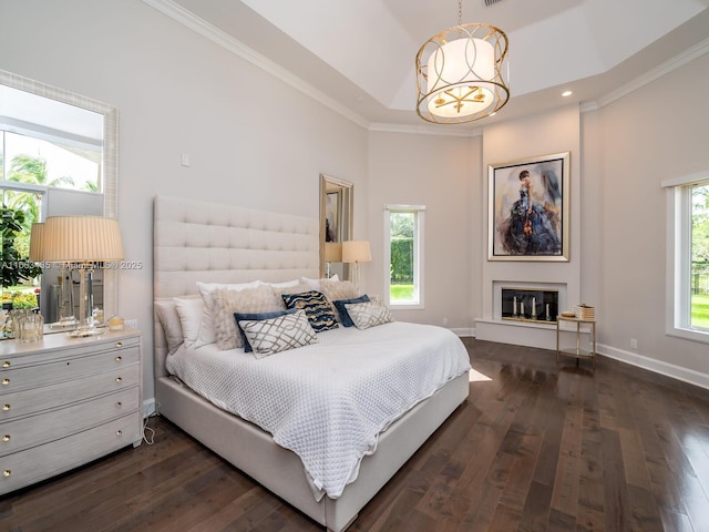 bedroom featuring a high ceiling, ornamental molding, dark hardwood / wood-style floors, and an inviting chandelier