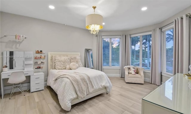 bedroom with a notable chandelier and light wood-type flooring