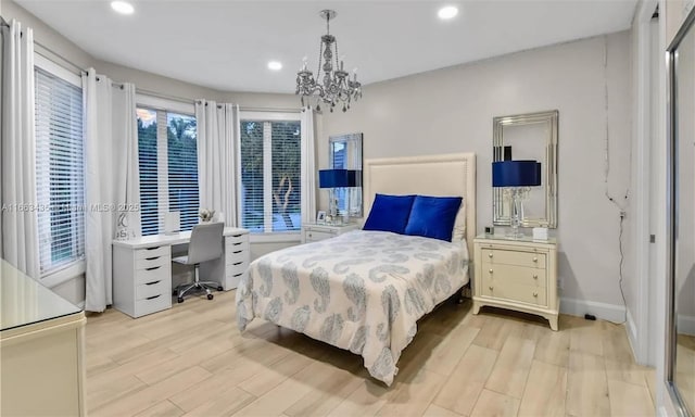 bedroom with a chandelier and light hardwood / wood-style flooring