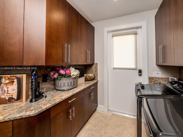 kitchen with dark brown cabinetry, light stone counters, tasteful backsplash, and independent washer and dryer