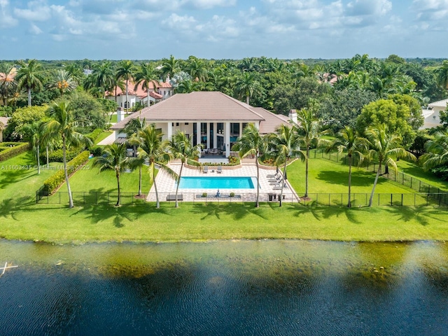 rear view of house with a fenced in pool, a water view, and a patio area