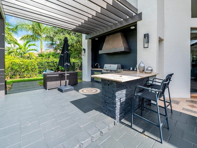 view of patio with exterior kitchen, outdoor lounge area, an outdoor wet bar, grilling area, and a pergola