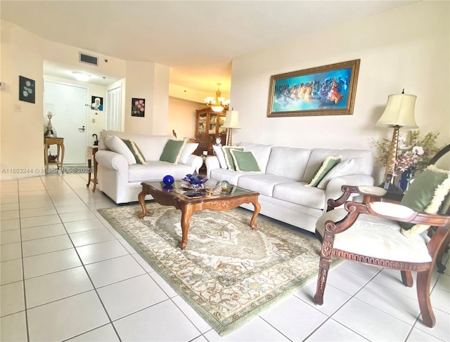 tiled living room featuring an inviting chandelier