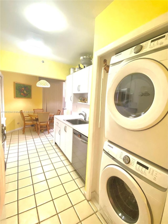 washroom with stacked washer and dryer, light tile patterned floors, and sink