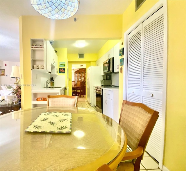 dining area featuring sink and light tile patterned floors