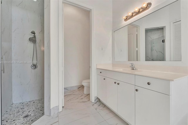 bathroom with tiled shower, vanity, and toilet