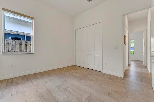 unfurnished bedroom featuring light hardwood / wood-style floors and a closet