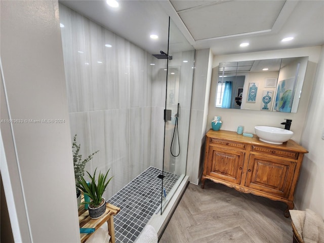 bathroom featuring parquet flooring, vanity, and walk in shower