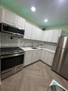 kitchen featuring sink, white cabinetry, and stainless steel appliances