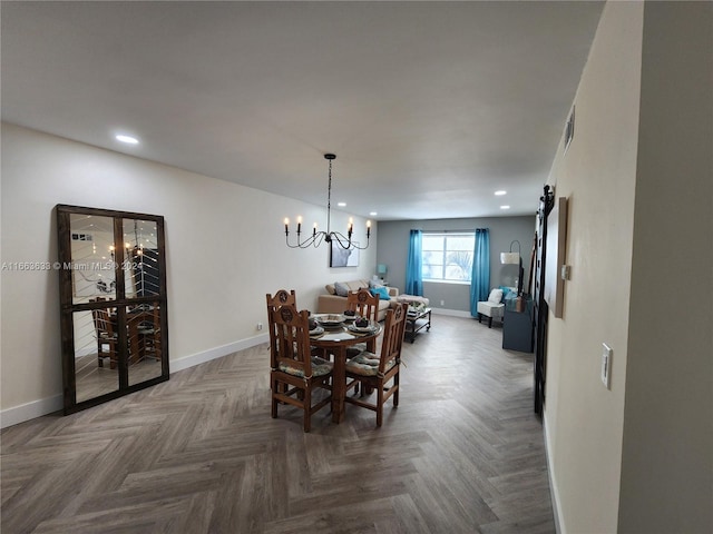 dining space featuring a barn door, an inviting chandelier, and parquet floors