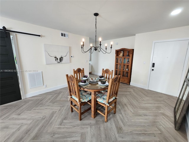 dining room featuring a barn door, light parquet flooring, and an inviting chandelier