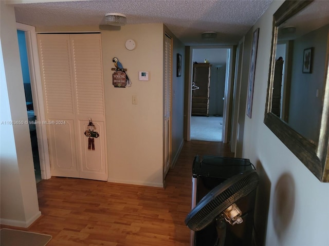 hallway featuring a textured ceiling and light wood-type flooring