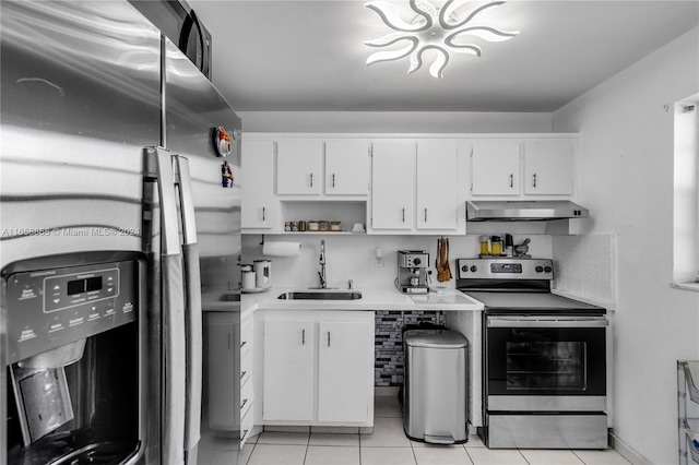 kitchen with white cabinets, appliances with stainless steel finishes, light tile patterned flooring, and sink