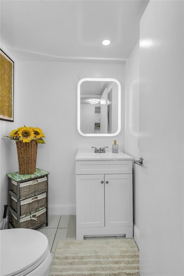 bathroom with toilet, vanity, and tile patterned floors