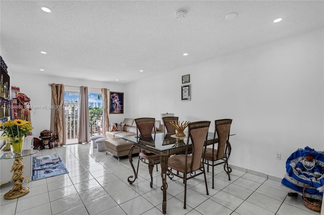 tiled dining room featuring a textured ceiling