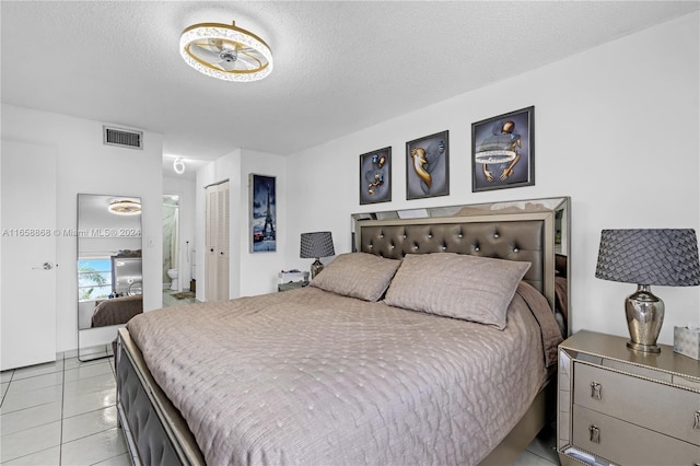 bedroom featuring light tile patterned floors and a textured ceiling