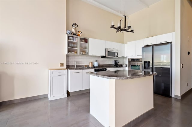 kitchen with a center island, white cabinetry, decorative light fixtures, and stainless steel appliances