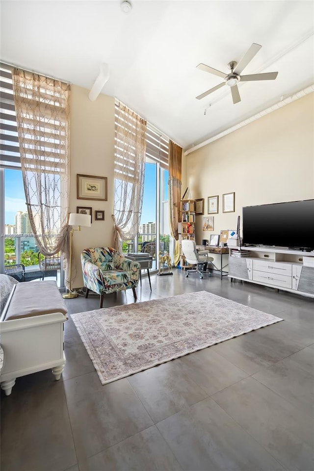 living room featuring expansive windows and ceiling fan